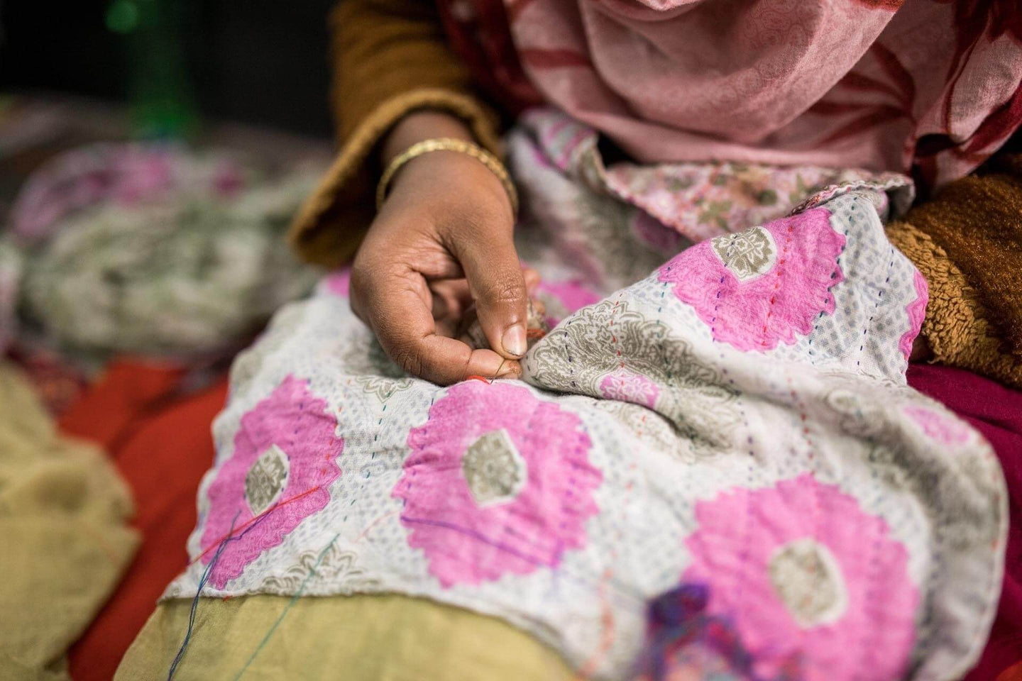 woman hand stitching kantha sari blanket